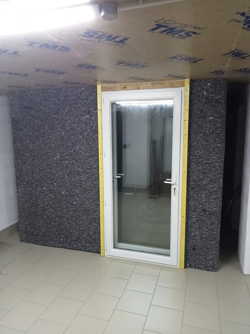 Cabine acoustique montée en paroi double dans un local, avec porte vitrée