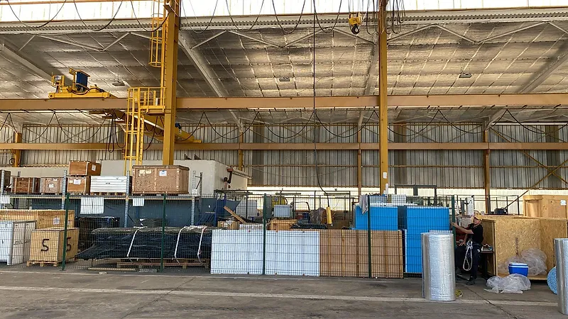 Vue intérieure d'un grand entrepôt à Kourou, en Guyane, dont la sous-face de toiture est doublée d'un isolant mince réfléchissant
